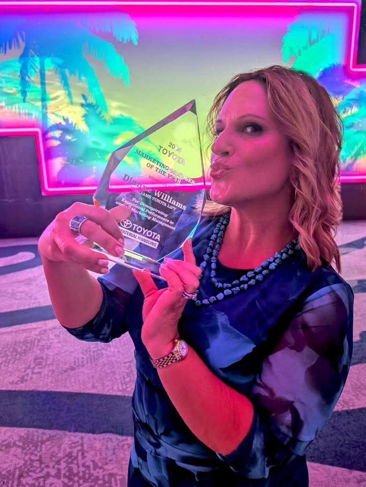 Dianne kissing crystal "Marketing Manager of the Year" award presented by Toyota Material Handling