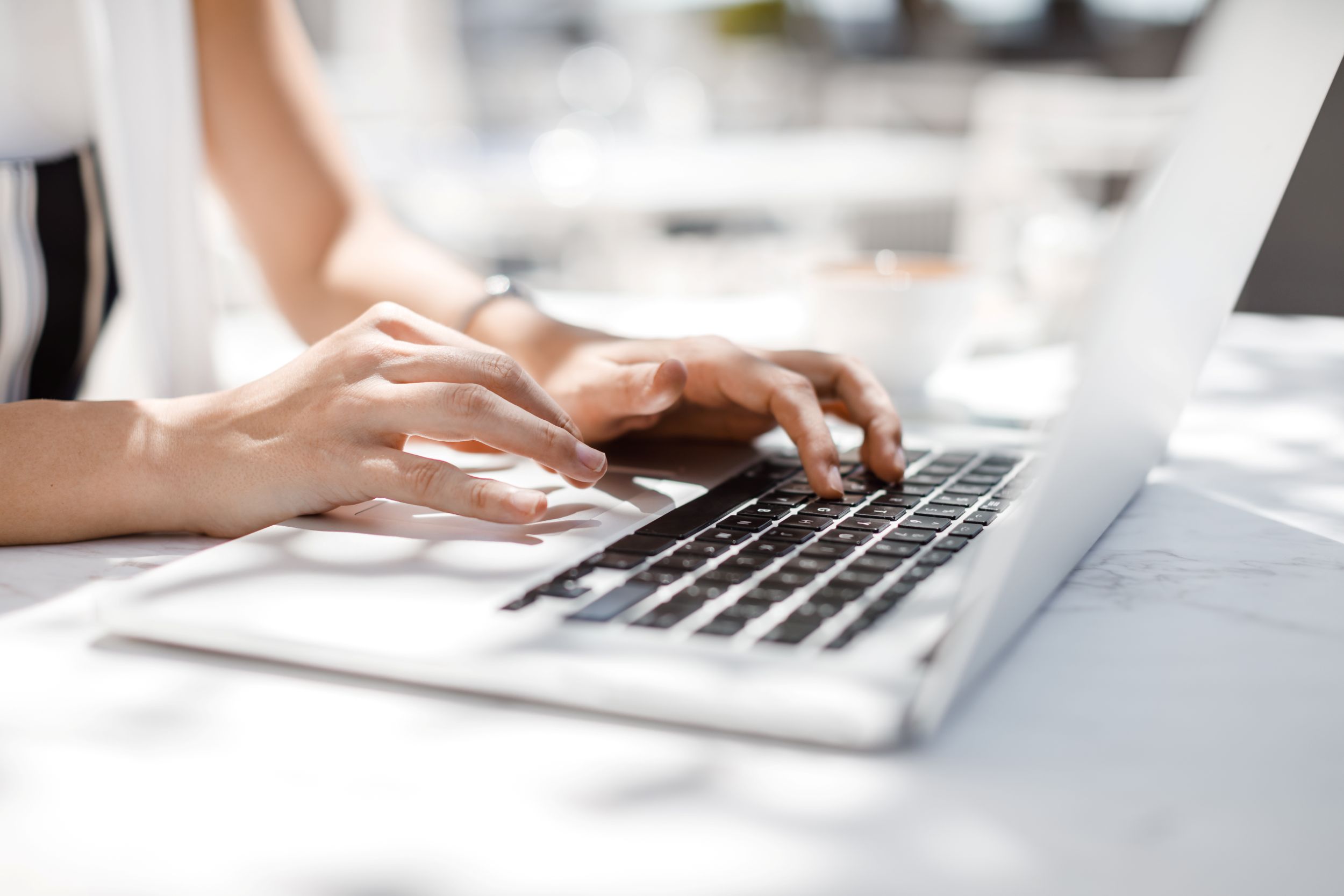 Photo of hands typing on laptop computer
